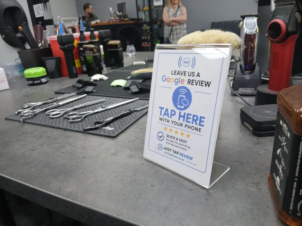 Google review stand displayed at a barber shop workstation